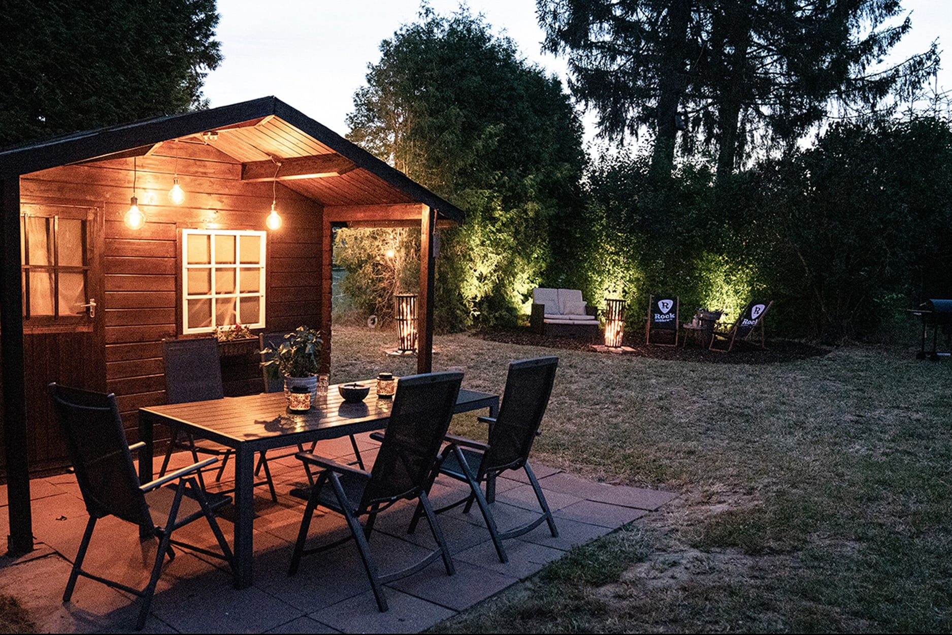 Großzügiger Garten im Tonstudio mit Sitzbereich, Gartenhaus und Lagerfeuerstelle.