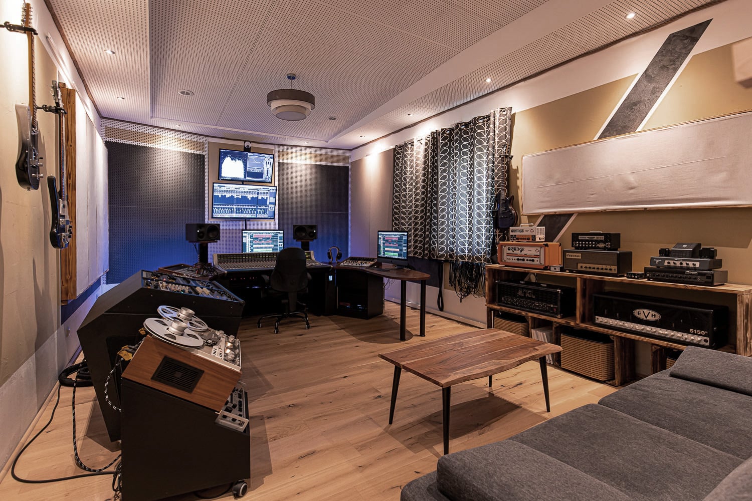 Regieraum in einem modernen Tonstudio mit Mischpult, Monitoren und Audiogeräten für die Musikproduktion.