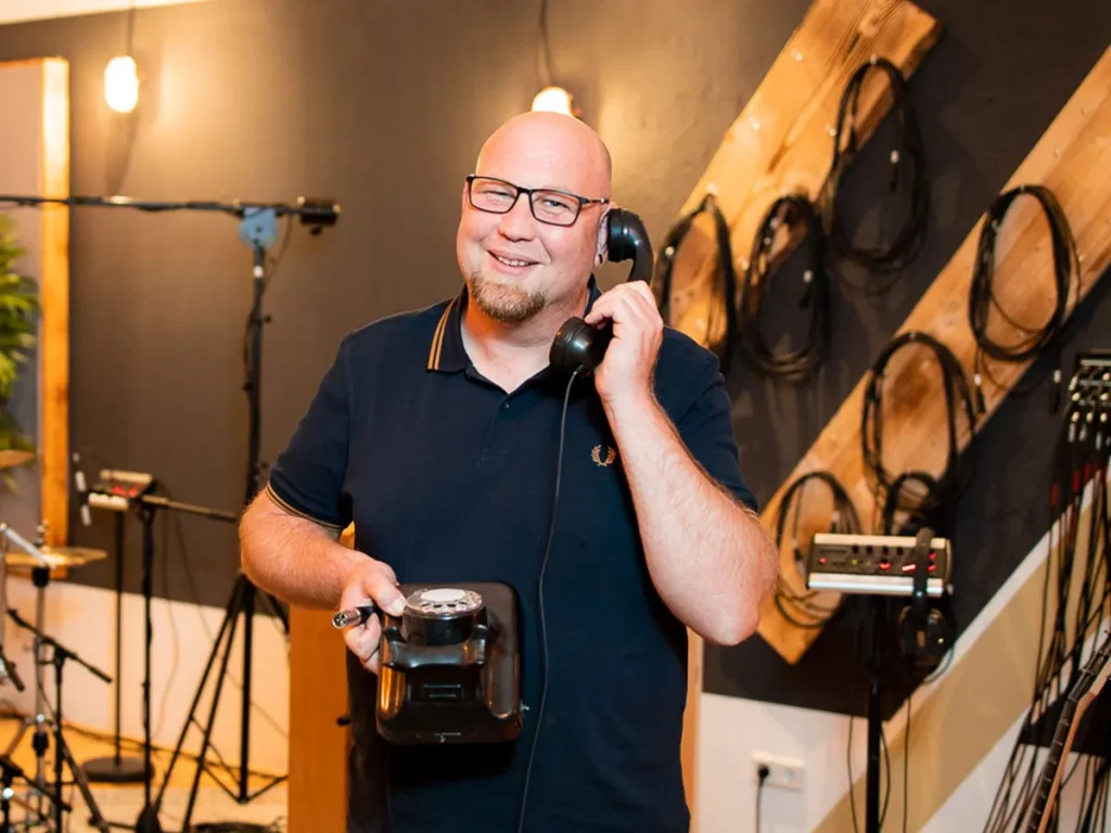 Tontechniker mit Telefonhörer im Aufnahmeraum der Rockmöhre