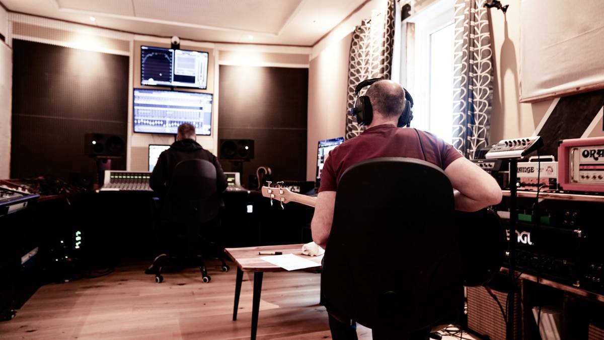 Musiker nimmt in der Regie auf und  schaut dabei fragend zum Mischpult